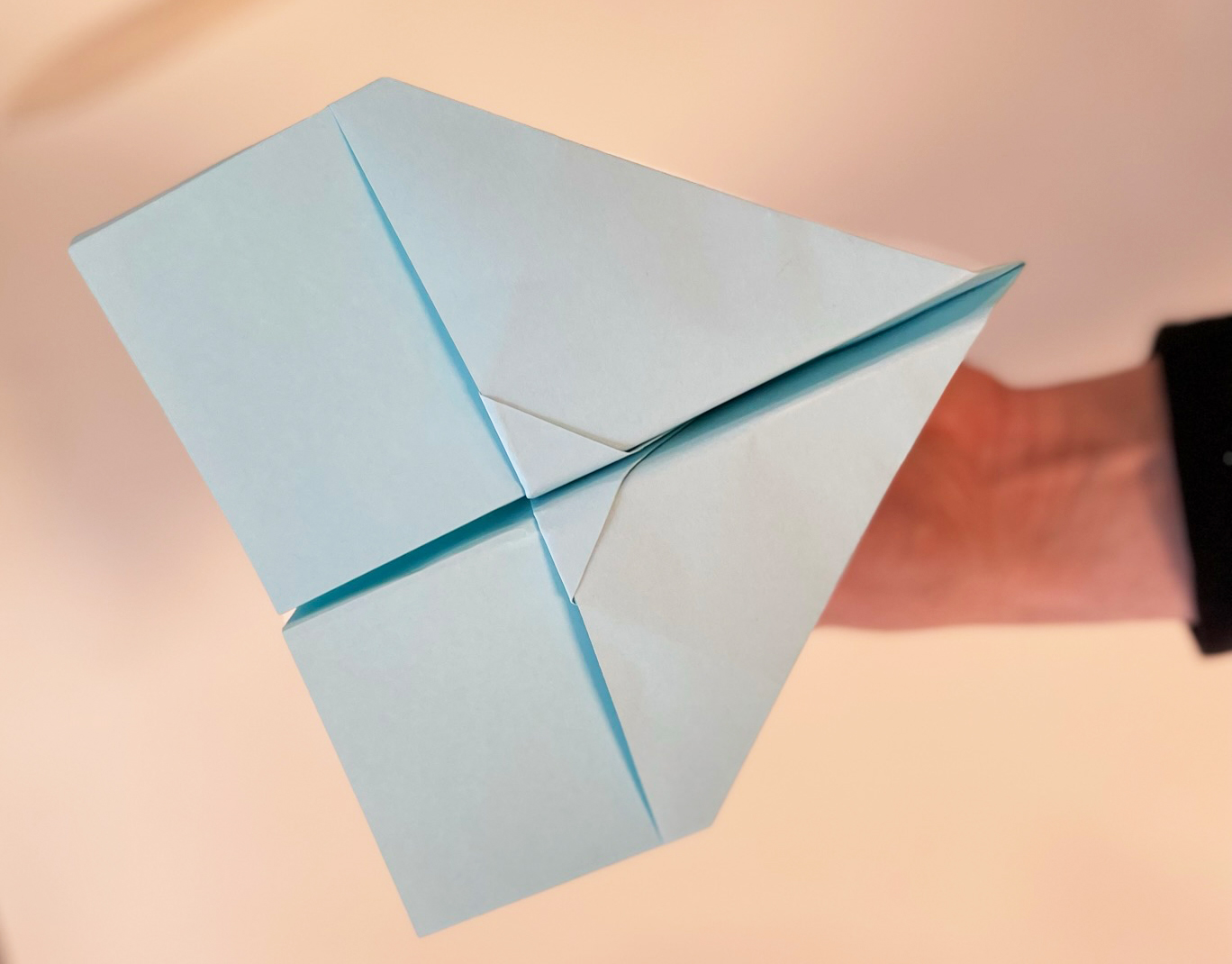 Hellblauer Papierflieger im Tauben-Design