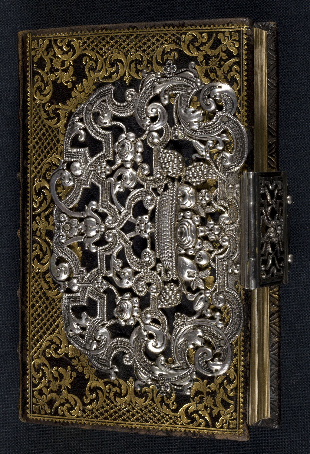 Dem mit Goldprägung reich verzierten Ledereinband ist eine Applikation aus Silber aufgebracht, welche die Schließe in der Mitte des Vorderschnitts umgreift. Der Silberschmuck besteht aus reichem Bandwerk mit floralen Ornamenten. Der Band stammt aus der Zeit um 1750.