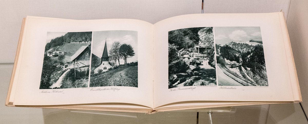 Aufgeklapptes Buch, zu sehen sind vier schwarzweiß Fotografien von verschiedenen Ortschaften.