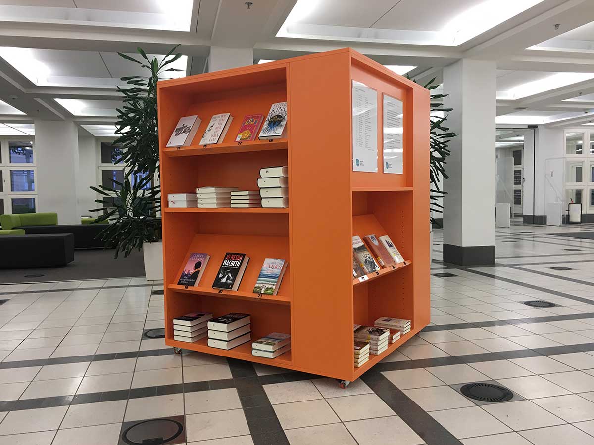 Foto: © Badische Landesbibliothek Zu sehen ist das orangene Bestsellerbücherregal im Foyer der BLB.
